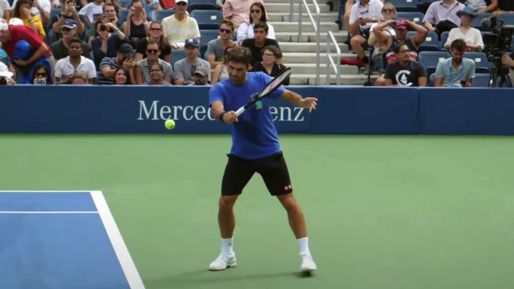 A player hitting a slice backhand with the racket face open and a high-to-low swing path