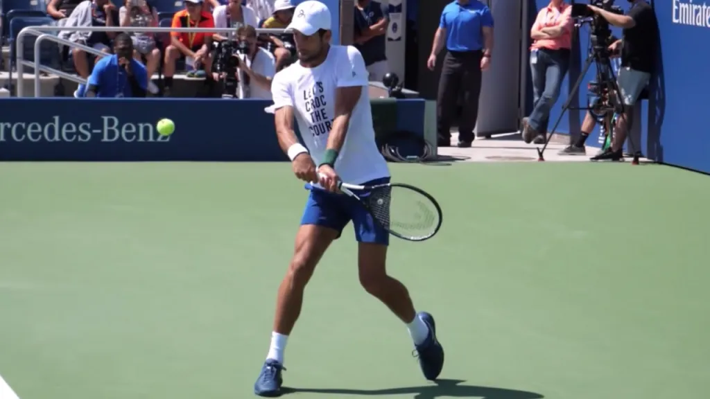 A player demonstrating proper two-handed backhand form with full shoulder rotation and balanced stance