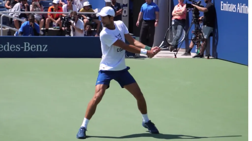 A player in the neutral forward stance preparing to hit a two-handed backhand with weight transferring to front foot