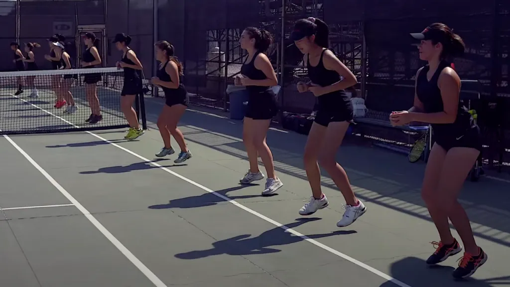 High school tennis player doing fitness drills on court