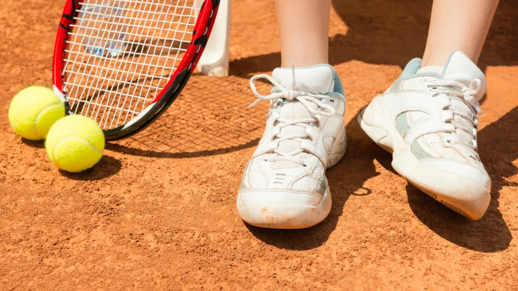 Tennis shoes on a clay court surface