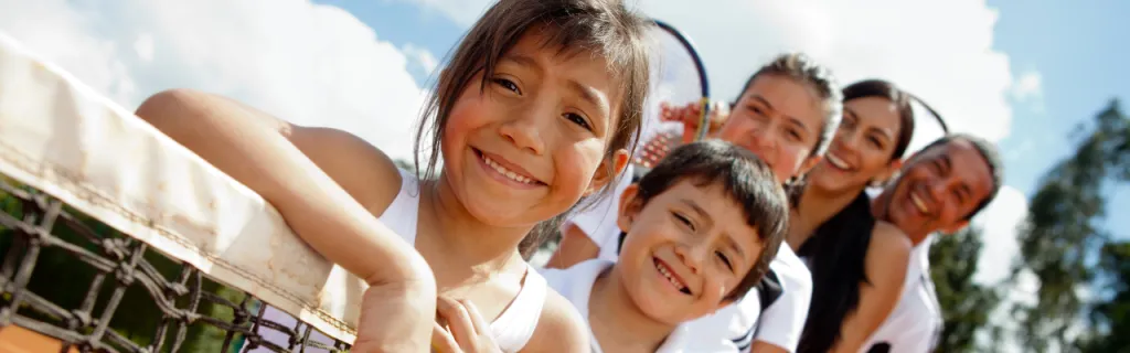 kids with parents on tennis court
