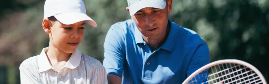 a tennis coach teaching proper grip technique