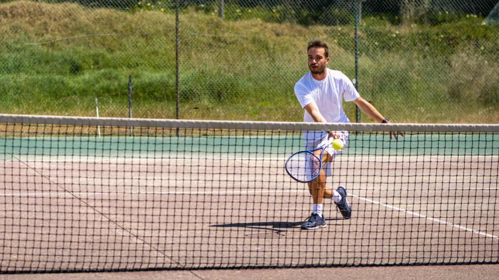 Tennis player at the net hitting a drop volley
