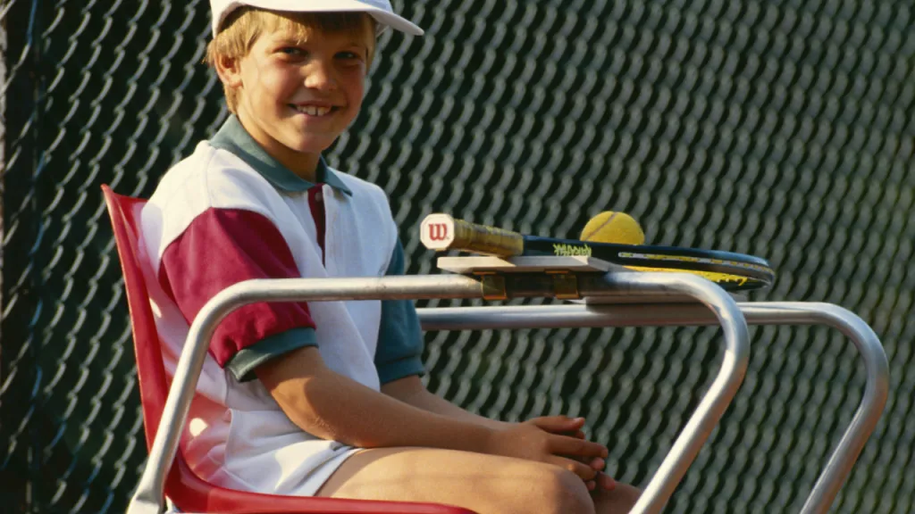 A young chair umpire keeping score during a tennis match